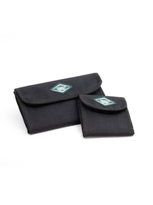 Two black cap pouches with flap closures and teal logo patches