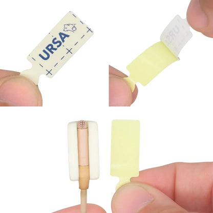 Cream adhesive tape pieces held between fingers, showing tab and backing