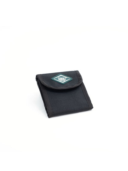 Black cap pouch with flap, teal logo patch, and compact folded design