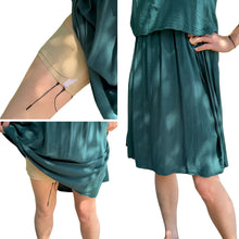 Teal fabric dress with beige thigh strap and pouch clipped on leg