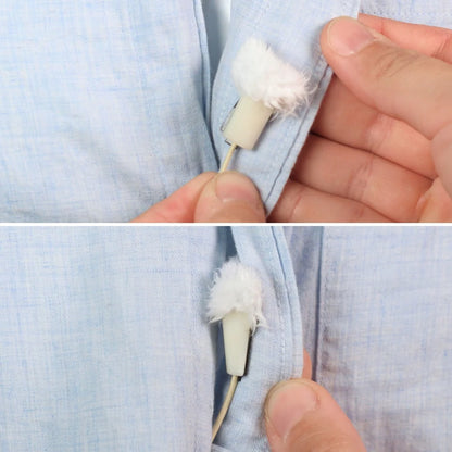 Hand holding a white plush circle short-fur wind protector stick against blue fabric