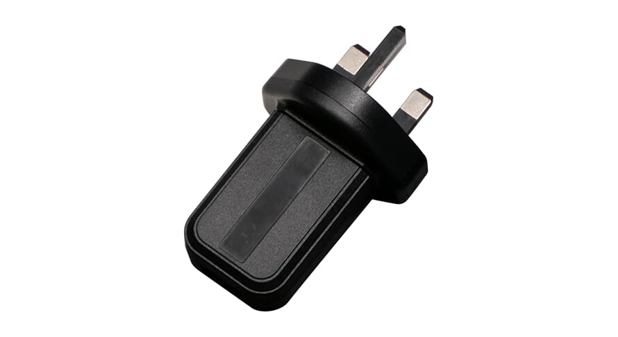 Black USB AC adapter plug with two metal prongs, angled view