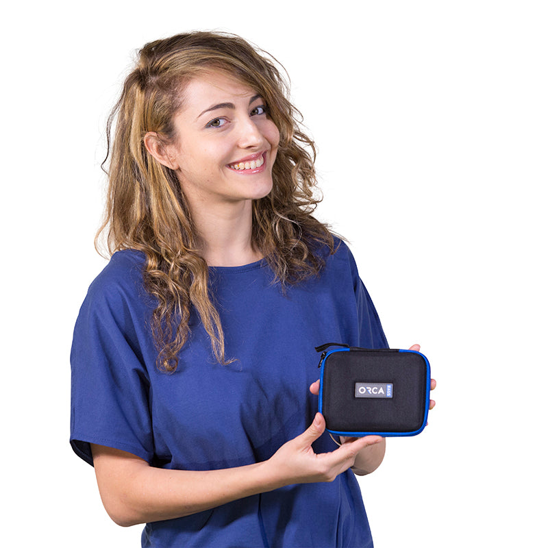 ORCA logo on dark gray capsule pouch with blue zipper trim, held in hand