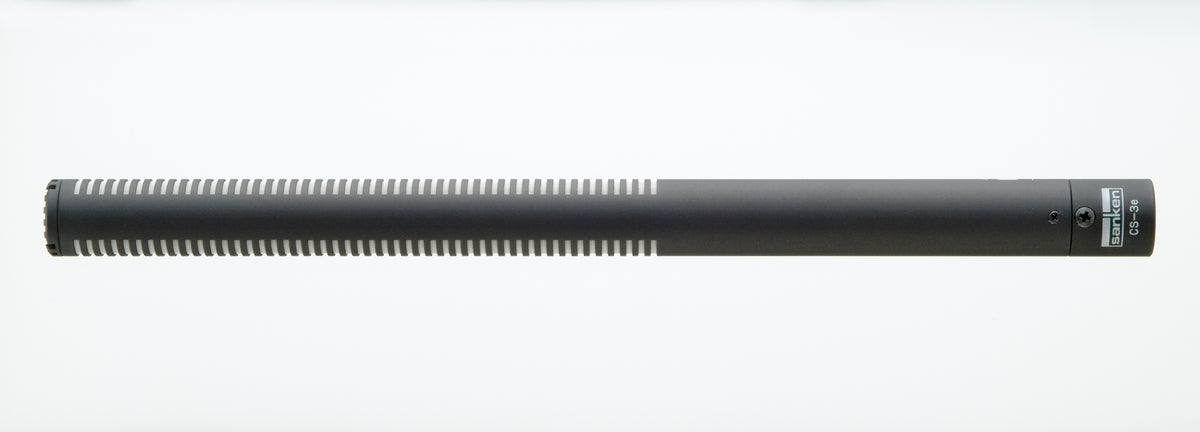 Shotgun microphone with long cylindrical body and side controls near the handle