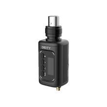 Black plug-on wireless transmitter with LCD screen, buttons, and metal audio plug