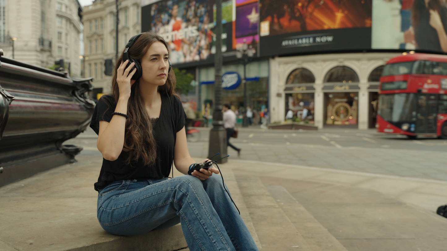 Digital IFB receiver in black, worn with an in-ear headset for communications