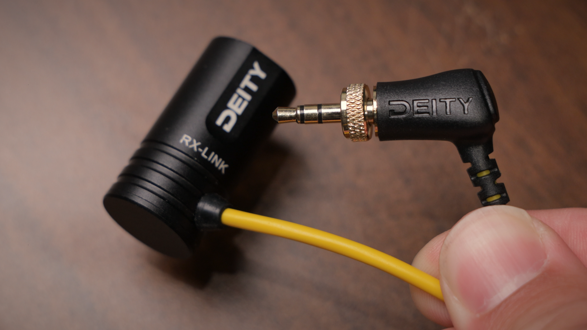 DEITY receiver antenna and audio connectors with yellow cable, handheld