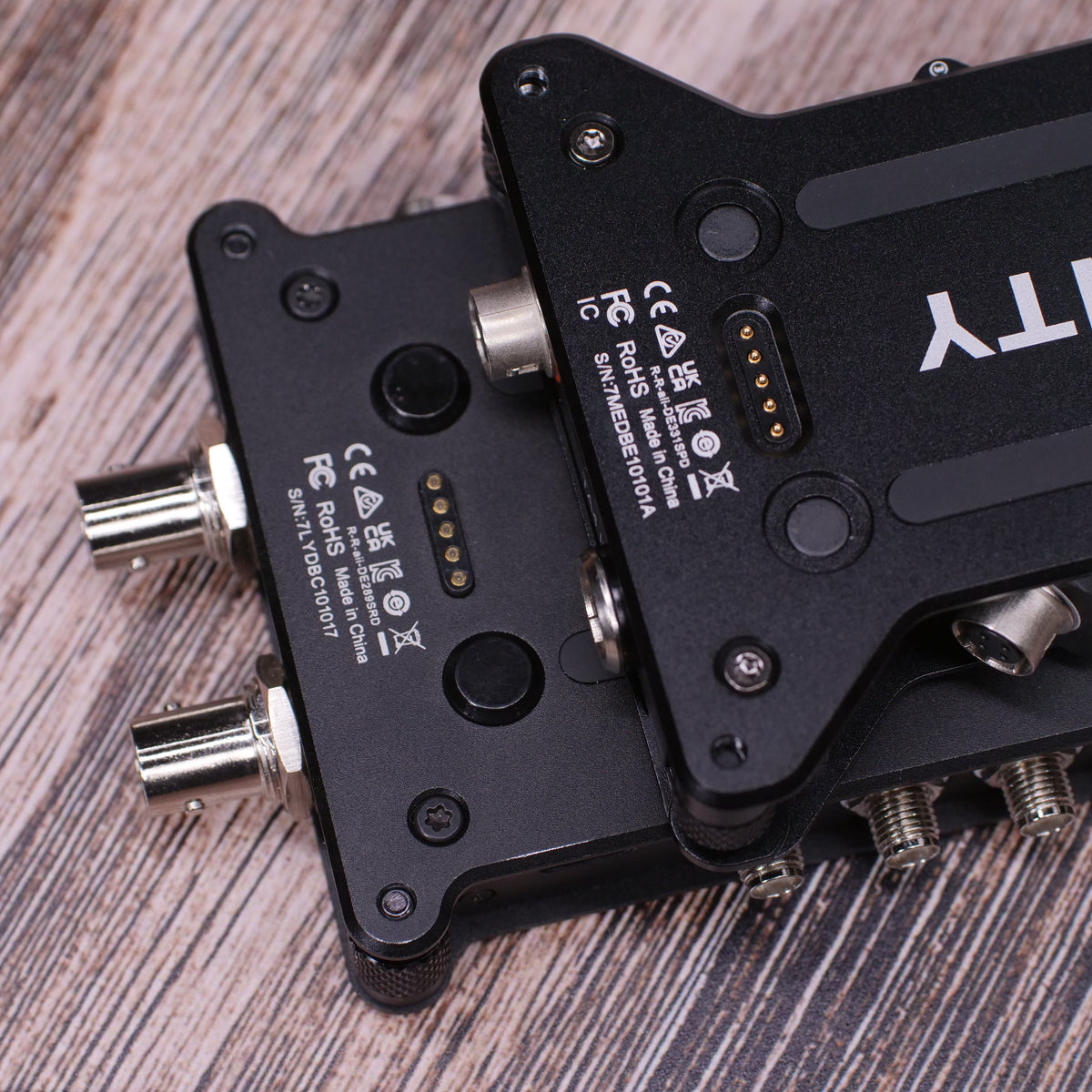 Back of black RF distributor unit with multiple connector ports on wood