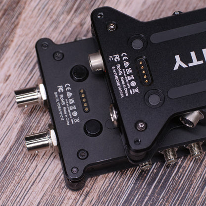 Back of black RF distributor unit with multiple connector ports on wood