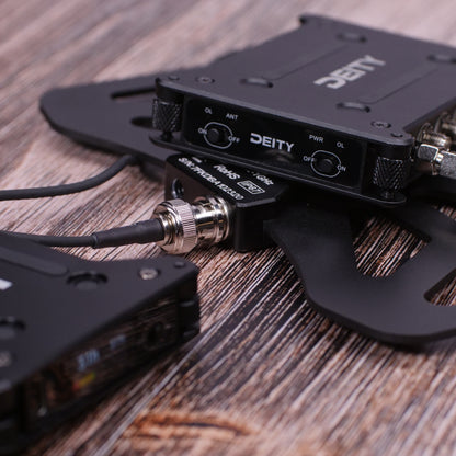 Black RF distributor unit on wood with ports and connected cables