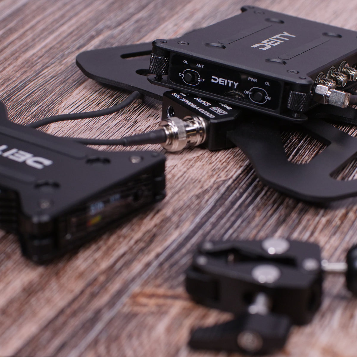 Black RF distributor units with connector ports and cables on wood tabletop