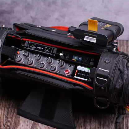 Black RF distributor module with knobs, display, and cable inputs on padded case