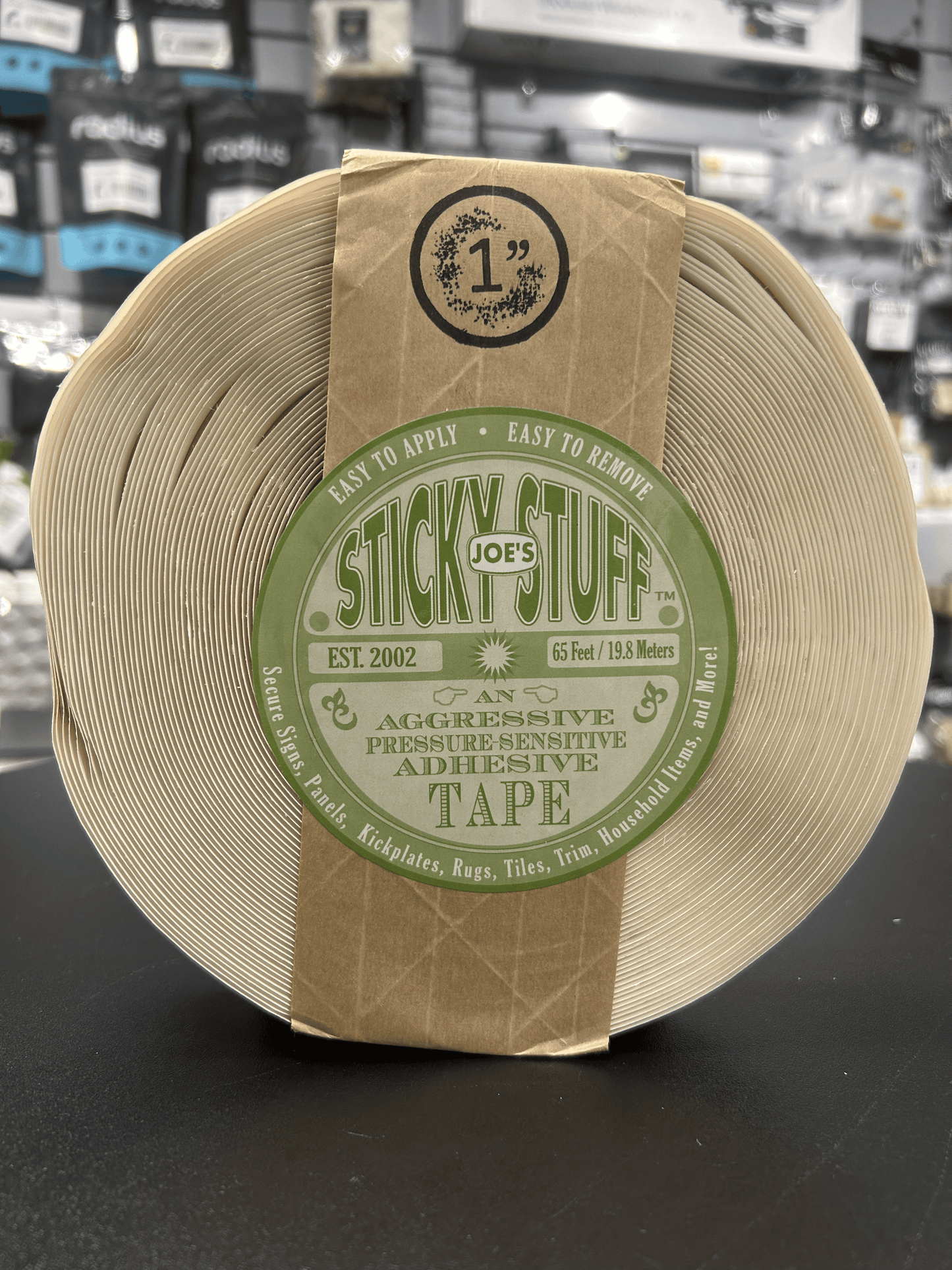 1 in adhesive tape roll with tan backing and green Stick'Em Stuff label