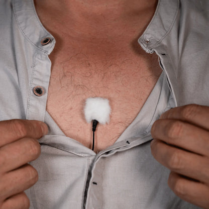 White lav mic cover pad placed on shirt front with cable