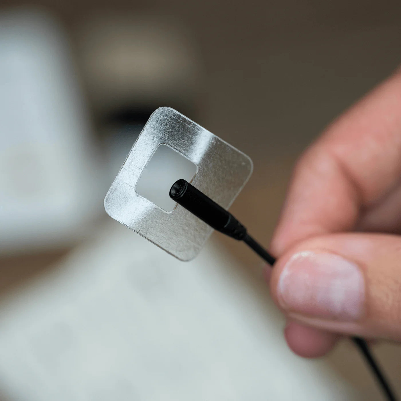 Adhesive lav tape applicator with silver clip and black cord