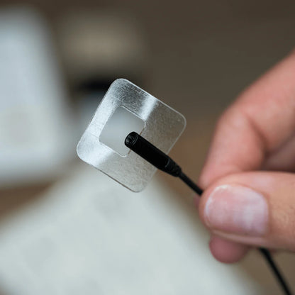 Adhesive lav tape applicator with silver clip and black cord