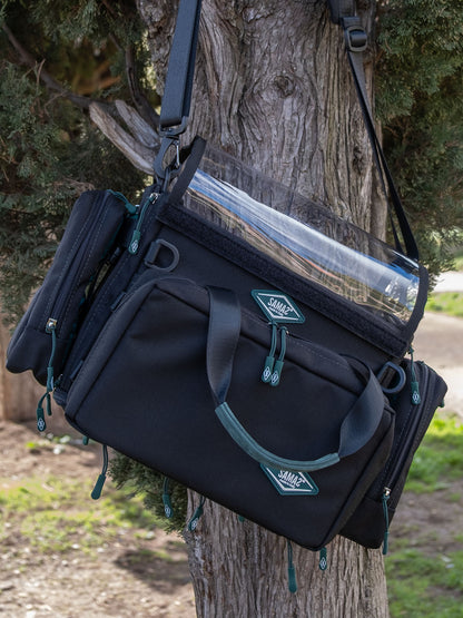 Small audio mixer bag in dark navy with front pockets, straps, and logo patch