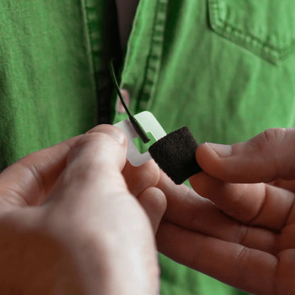 Mic hiding clip with black foam pad shown being attached to a microphone