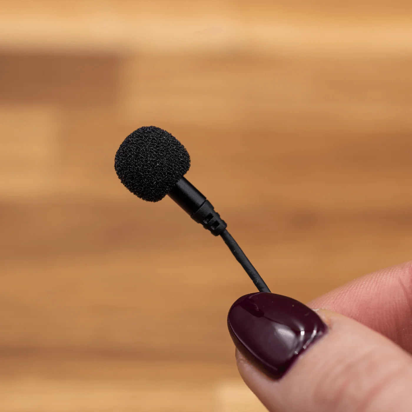 Black round foam windscreen for a lavalier microphone with small cable connector