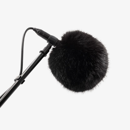 Black fuzzy microphone windscreen ball mounted on a microphone