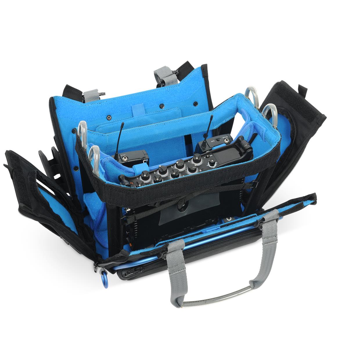 Audio mixer bag open with multiple compartments, blue lining, and mounted audio gear.