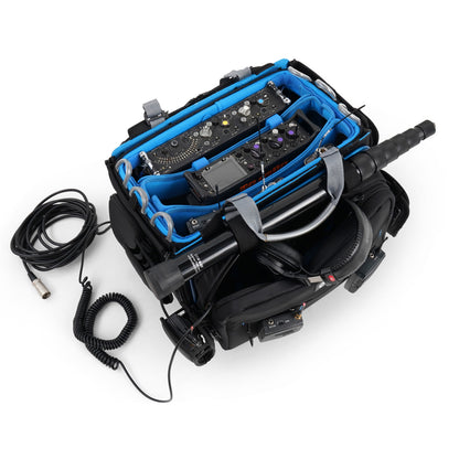 Audio mixer bag with blue-lined compartments holding mixer controls and cables