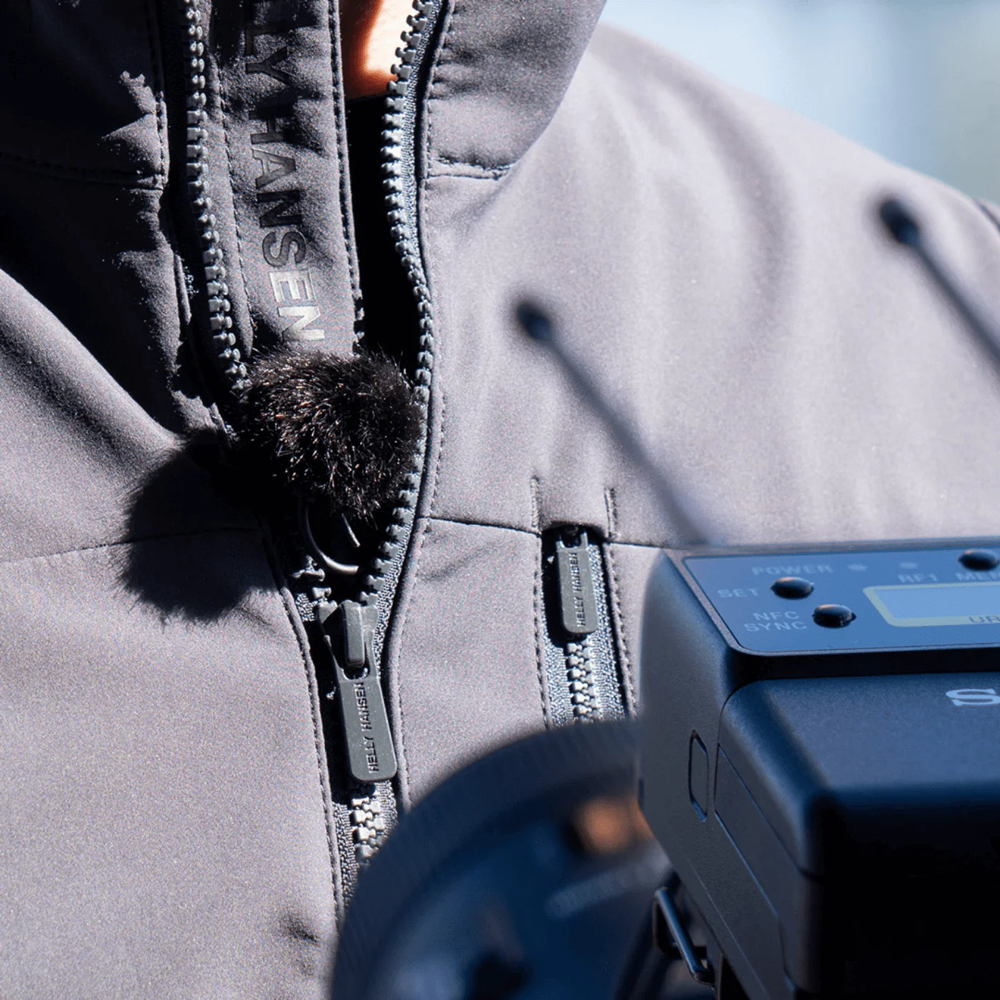 Outdoor mic kit on a light gray jacket with clip microphone and transmitter