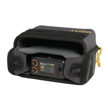 Gray audio bag holding a compact controller with visible screen and knobs