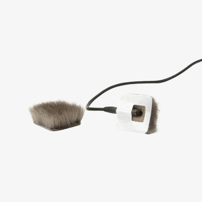 Small grey faux fur patch connected to a square backing piece with cable
