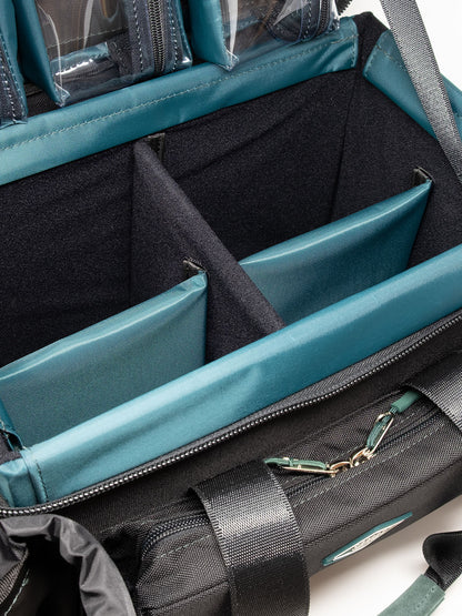 Accessory case interior view with teal dividers and a zippered pocket with clips