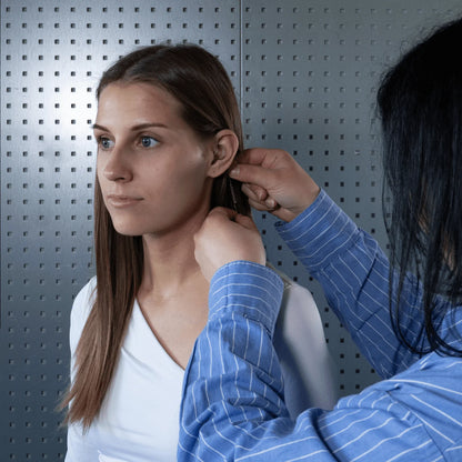 Broadcast earpiece with in-ear mic being adjusted on a woman’s ear