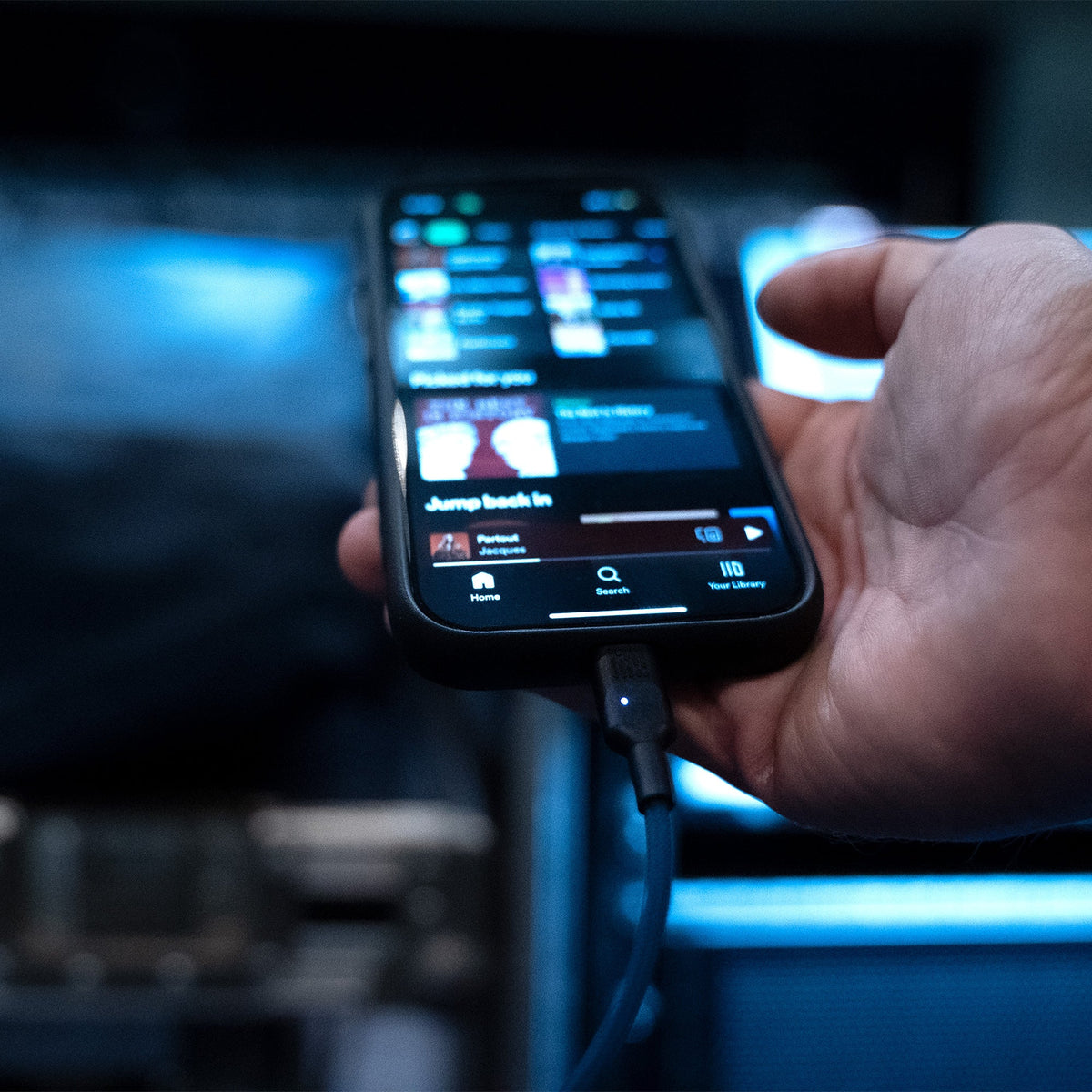 Sonnect SoundWire USB-C connector held in hand with a blue-lit control display and connected cable