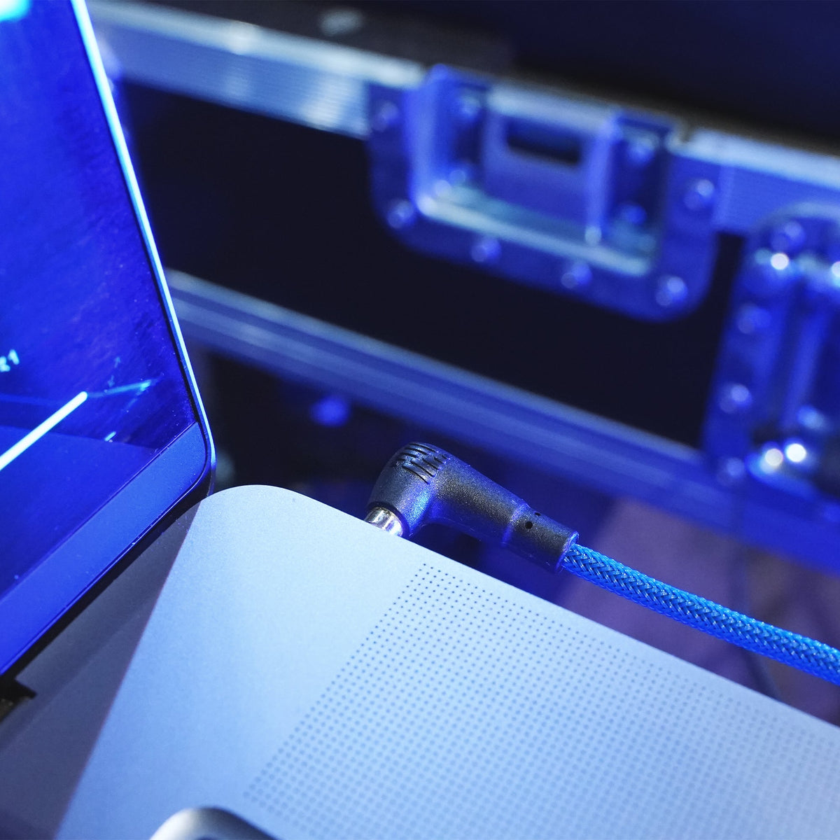 Braided blue audio cable connected to a laptop headphone jack