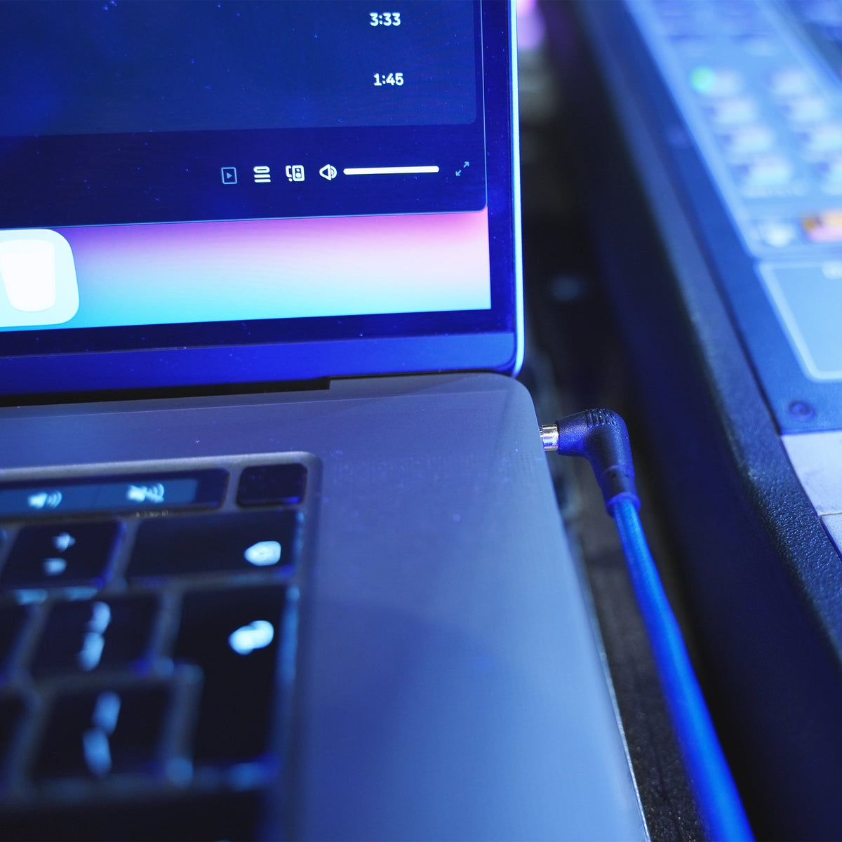 Blue audio cable plugged into a laptop headphone port