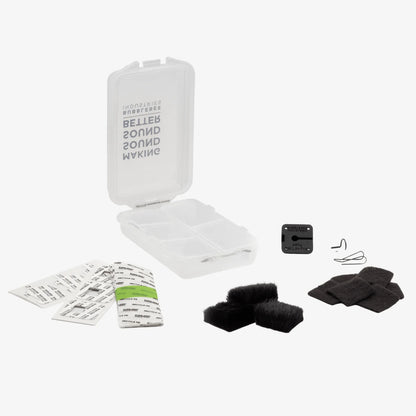 Mic hiding kit contents: clear case, black wind muff, pads, and small mounting parts