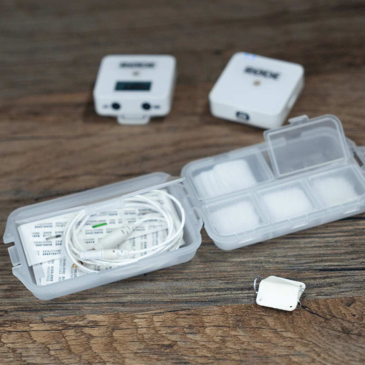 Mic Hiding Kit case with cables, small clips, and accessory compartments on wood