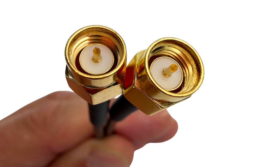 Close-up of gold SMA connectors on black cable ends