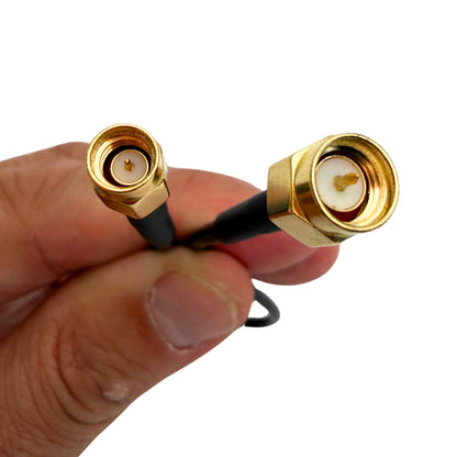 Close-up of two gold SMA connector ends on a black cable