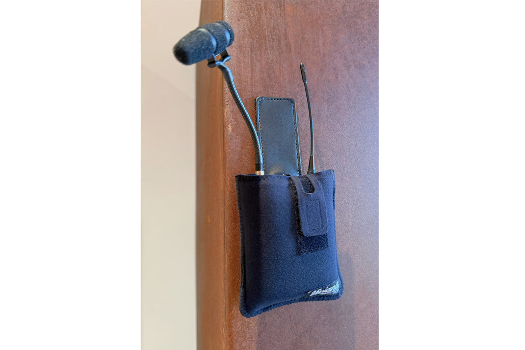 Blue fabric IFB/IEM pouch with magnetic clip, mounted on a vertical surface