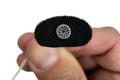 Close-up of a dark foam pad with a circular metal mesh insert