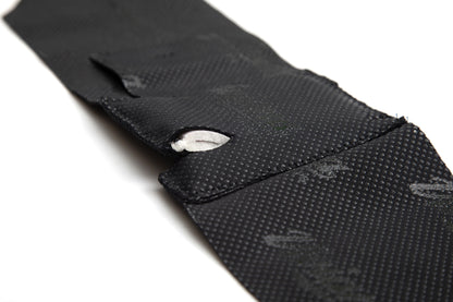 Black ankle strap with textured surface and Velcro loop tab detail