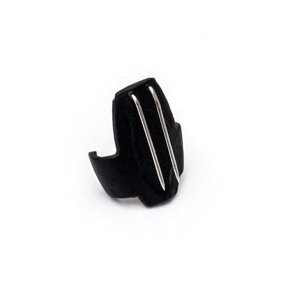 Black beetle-shaped clip with two silver metal prongs, close-up