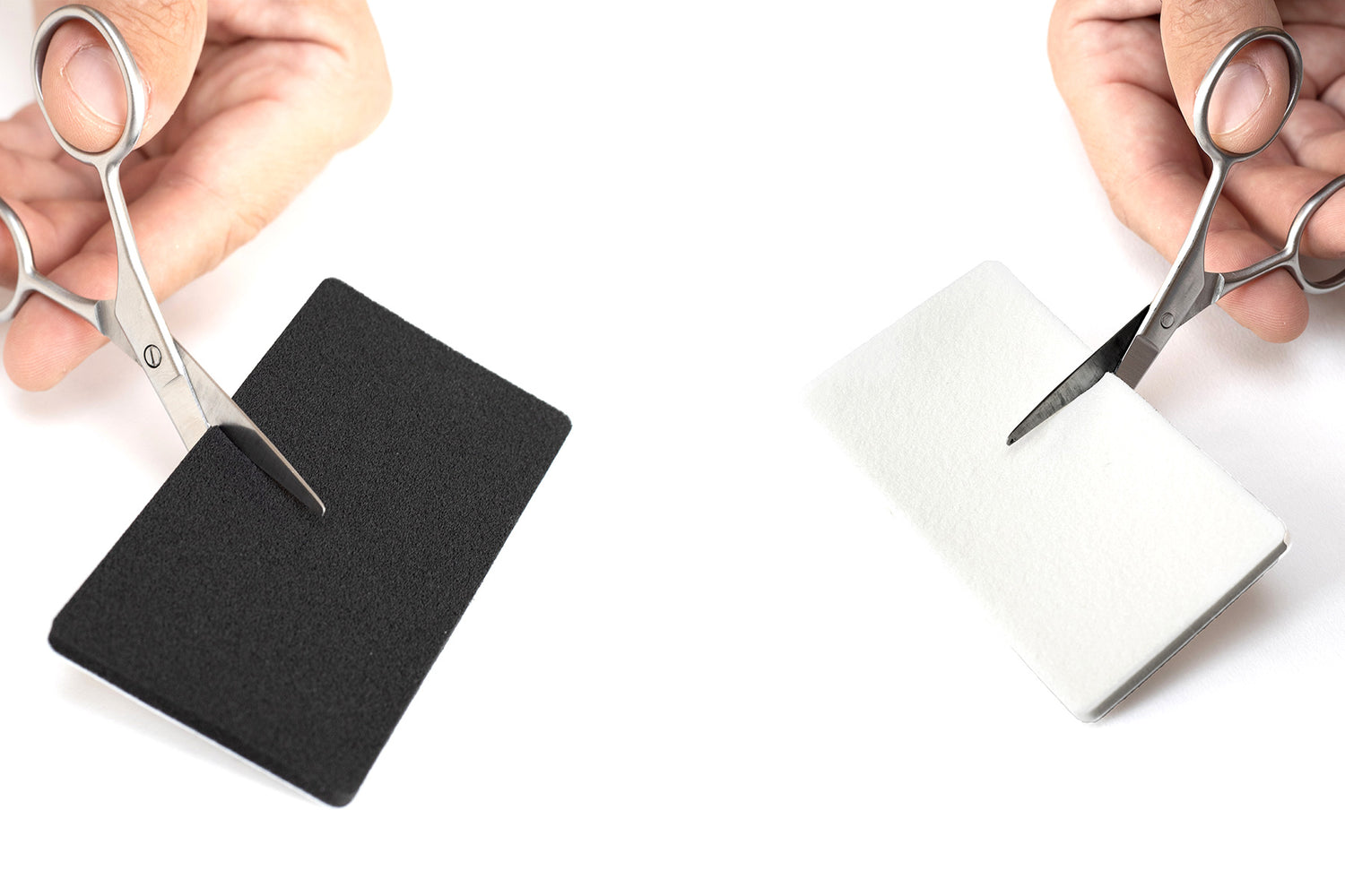 Square foam pads being cut with scissors, black and white