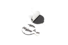 White backed adhesive dot stickers with black printed text, one peeled away