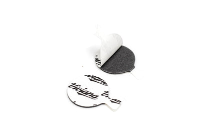 White backed adhesive dot stickers with black printed text, one peeled away