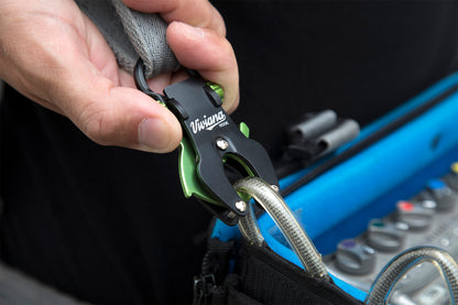 Hand installing a black-and-green hook tool on a gray bag strap