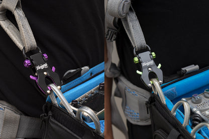 Two black-and-color hook tools on a blue tool bag with gray straps