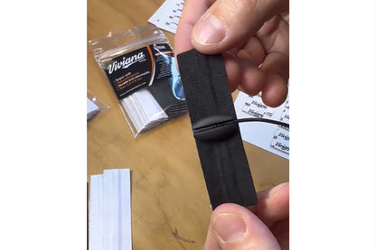 Black self-adhesive moleskin strip held between fingers