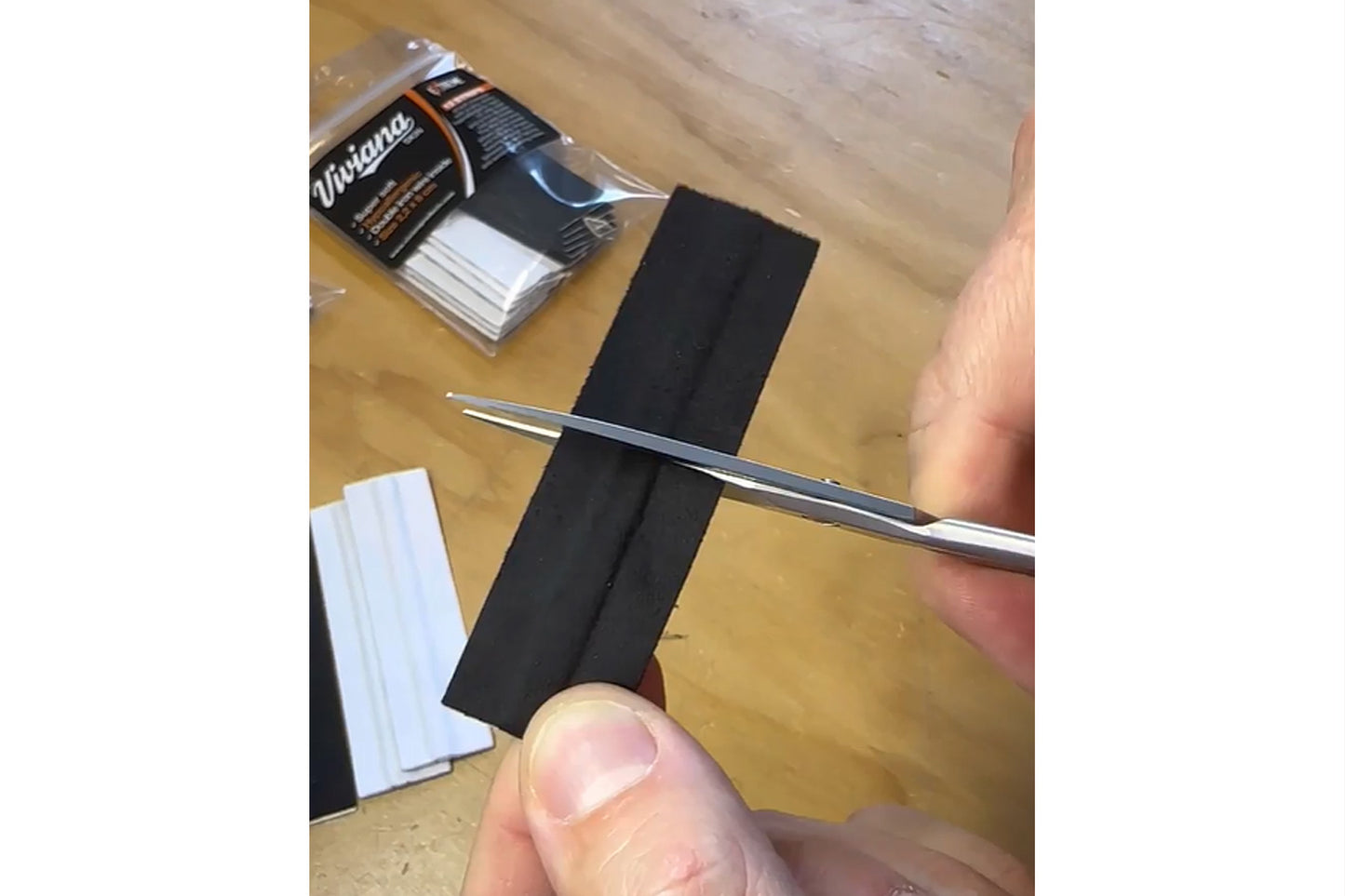 Moleskin strips and scissors cutting a black strip