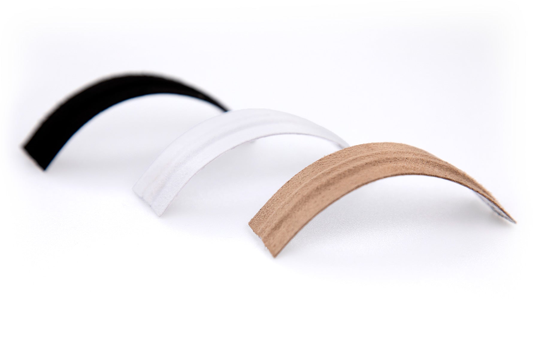 Moleskin strips, one white and one beige, with curved ends